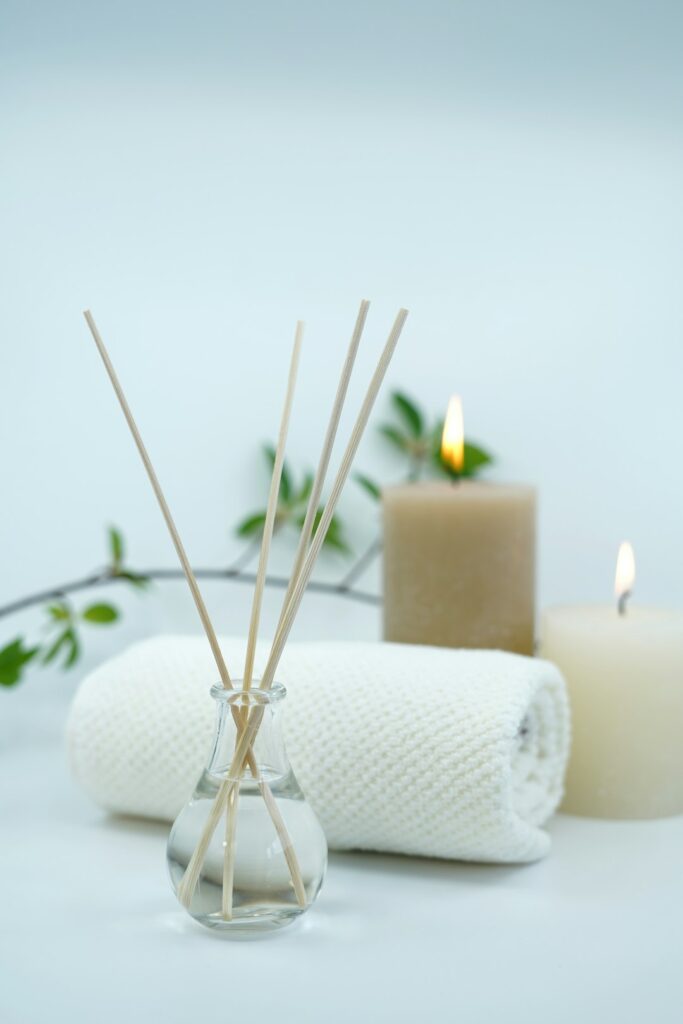 Beautiful image with spa and relaxing concept with scented oil fragrance diffuser and candles and towels
